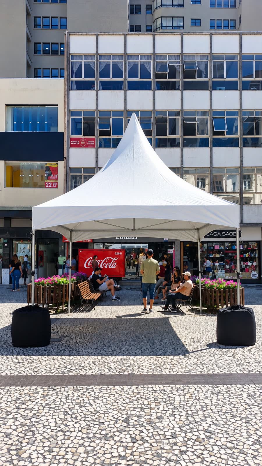 Tenda chapéu de bruxa branca montada em um calçadão no centro da cidade